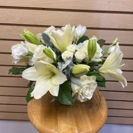 White lilies and roses arranged in a low bouquet