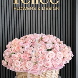 Large basket of pale pink roses with a ribbon bow