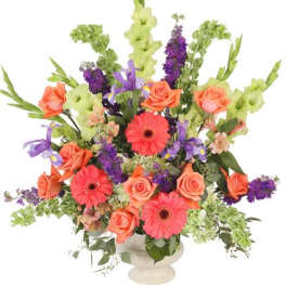 Colorful mixed flower arrangement in a white pedestal vase