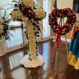 Large floral cross and heart-shaped rose wreath on stands