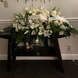 White floral arrangement with lilies and roses on a table