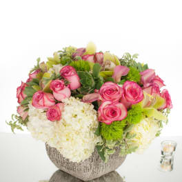 Low centerpiece of pink roses and white hydrangeas in a gray bowl vase