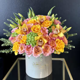 Pink and yellow rose bouquet in a white hat box with orchids
