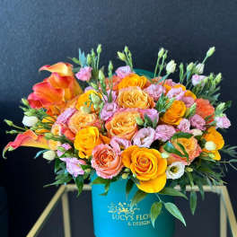 Bouquet of orange and pink roses with calla lilies in a turquoise box