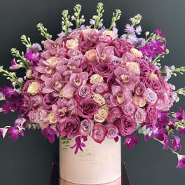 Pink and purple rose bouquet in a white hat box