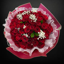 Bouquet of red roses with white baby's breath in pink wrapping