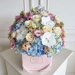 Pastel bouquet of roses, hydrangeas, and white orchids in a pink box