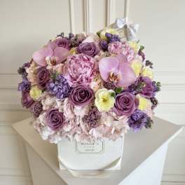 Bouquet of pink and purple flowers in a white box