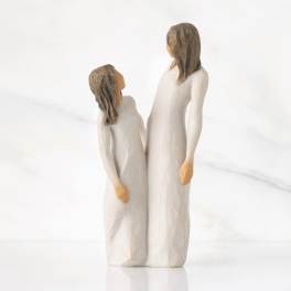 Two carved figurines of a woman and child in white robes