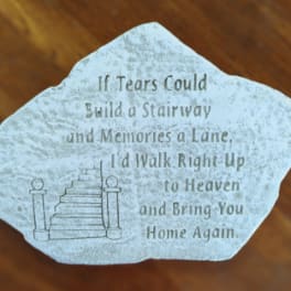 Memorial stone with a staircase illustration and engraved quote