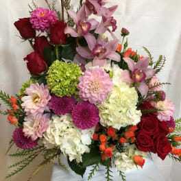 Mixed bouquet with red roses, pink orchids, and hydrangeas in a vase