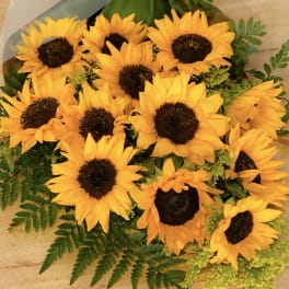 Bouquet of yellow sunflowers with dark centers and green foliage
