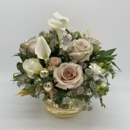 Low gold bowl arrangement with blush roses, white calla lilies, and mixed white flowers with gold accents.