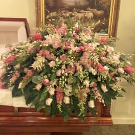 Large pink and white floral spray on a casket