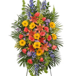 Standing floral spray with yellow, pink, orange, and purple flowers