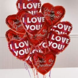 Cluster of red heart-shaped balloons with love messages