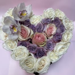 Heart-shaped bouquet of pink, purple, and white roses with white orchids