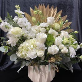 White roses and hydrangeas in a blush vase with gold fan accents