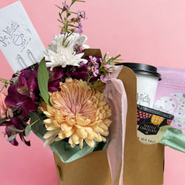 Bouquet with peach and purple flowers beside a gift box and chocolate cup