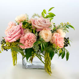 Pink and cream roses arranged in a clear glass vase
