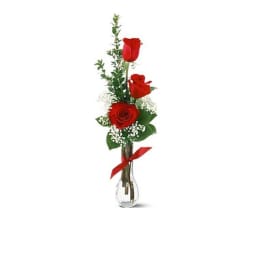 Tall red rose arrangement in a clear glass vase with a red ribbon