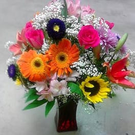 Mixed bouquet of bright gerbera daisies and roses in a vase