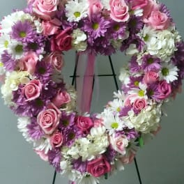 Heart-shaped floral wreath with pink roses and white and purple daisies