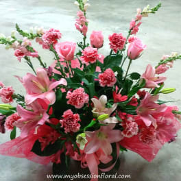 Pink lilies, roses, and carnations in a decorative bouquet
