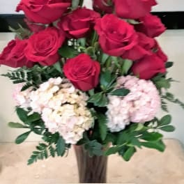 Bouquet of red roses and pale hydrangeas in a tall vase