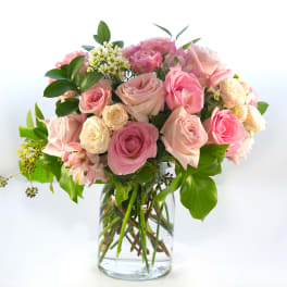 Pink and cream roses arranged in a clear glass vase