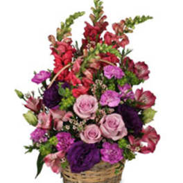 Basket arrangement of pink, purple, and red flowers