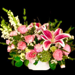 Pink roses and lilies arranged in a white basket