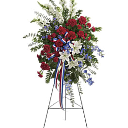 Standing floral spray with red, white, and blue flowers on an easel