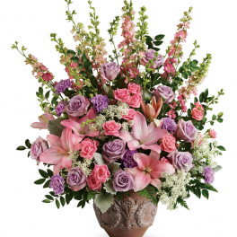 Large pink and lavender floral arrangement in a decorative vase