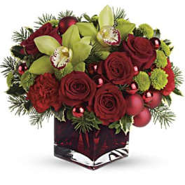 Red roses and green orchids in a square glass vase