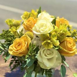 Yellow and white roses with yellow alstroemeria in a glass vase