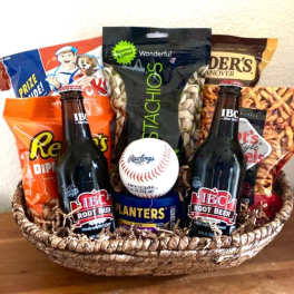 Basket of snacks with two root beer bottles and a baseball