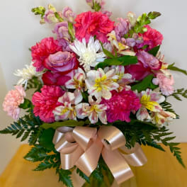 Bouquet of pink carnations, roses, and white alstroemeria with a satin ribbon