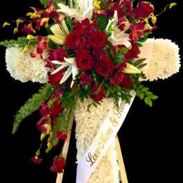 Standing floral spray with red roses, white lilies, and orchids on an easel