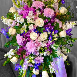 Large bouquet of pink, purple, and white flowers with ribbon tails