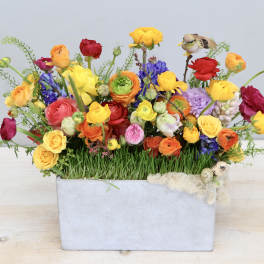 Colorful mixed bouquet in a rectangular gray container