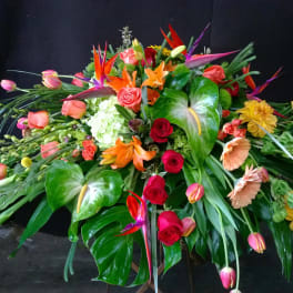 Large tropical floral arrangement with roses, lilies, and bird-of-paradise