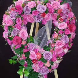 Heart-shaped rose wreath on a wooden easel with trailing ivy