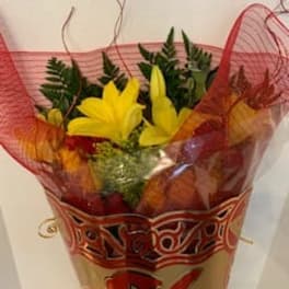 Bouquet of yellow lilies wrapped in red mesh paper