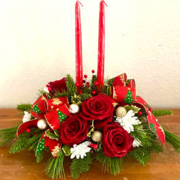 Red rose centerpiece with candles and holiday ribbon
