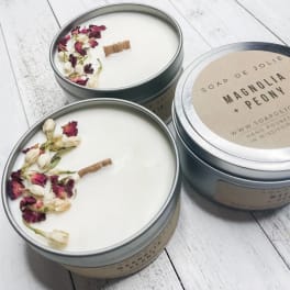 Three round tin candles with dried flower petals on top