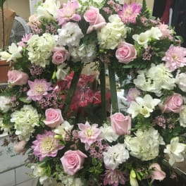 Large pink and white floral wreath on a stand