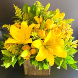 Yellow lily and rose bouquet in a square container