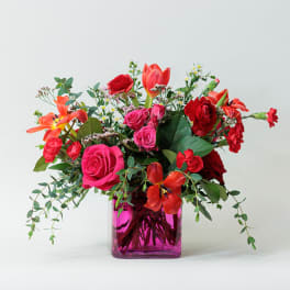 Bright mixed bouquet in a pink glass vase