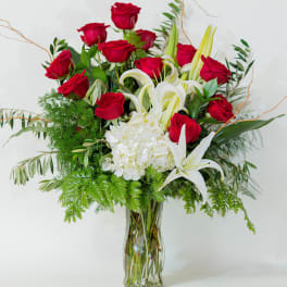 Red roses and white lilies in a clear glass vase